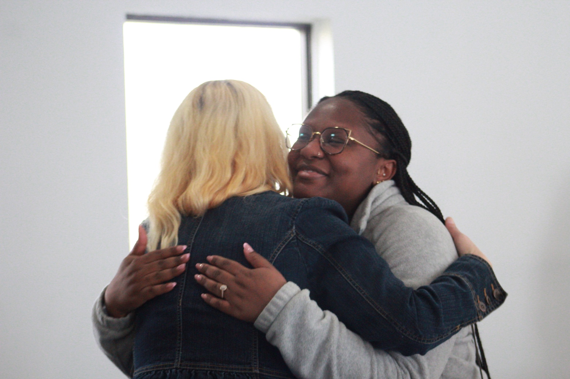 Members embracing at Fullness Church — Moyock families find a church home in Chesapeake