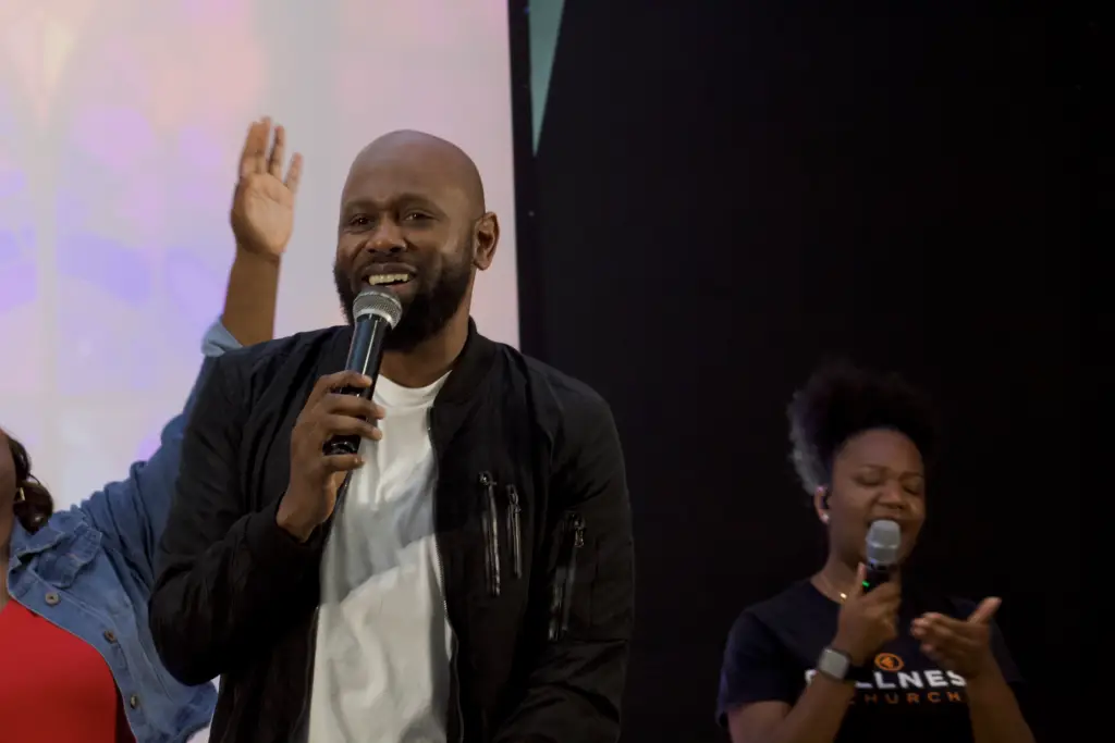 a man holding a microphone and raising his hand